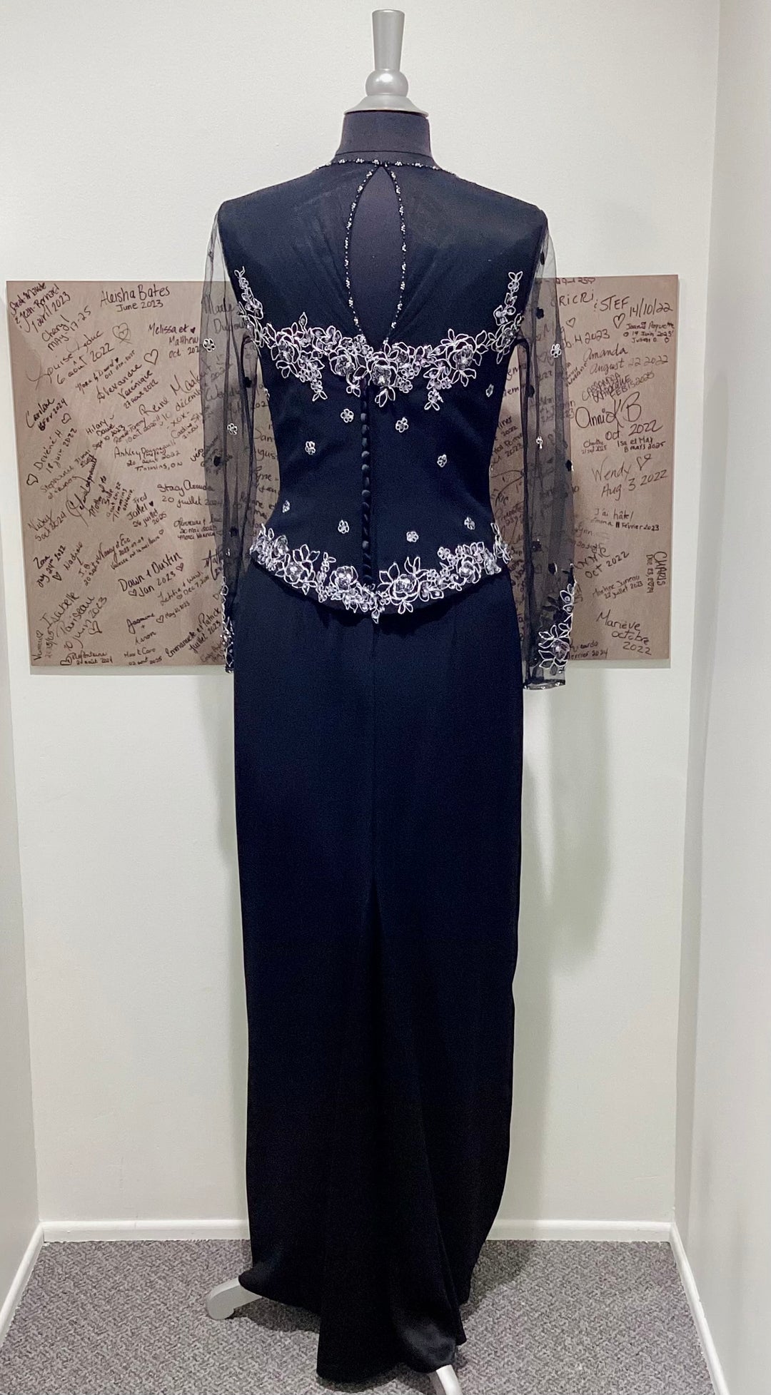 Navy evening gown with silver embellishments on a mannequin against a plain background