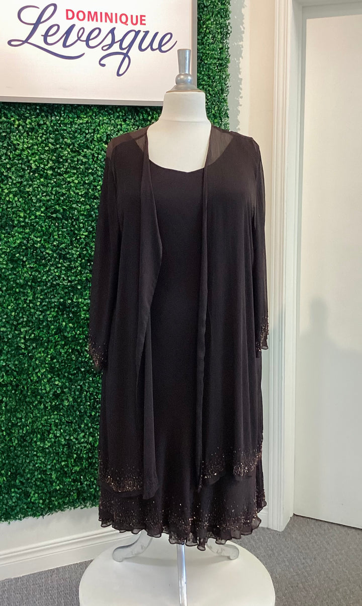 Brown dress with lace details on a mannequin against a green wall, featuring the brand &