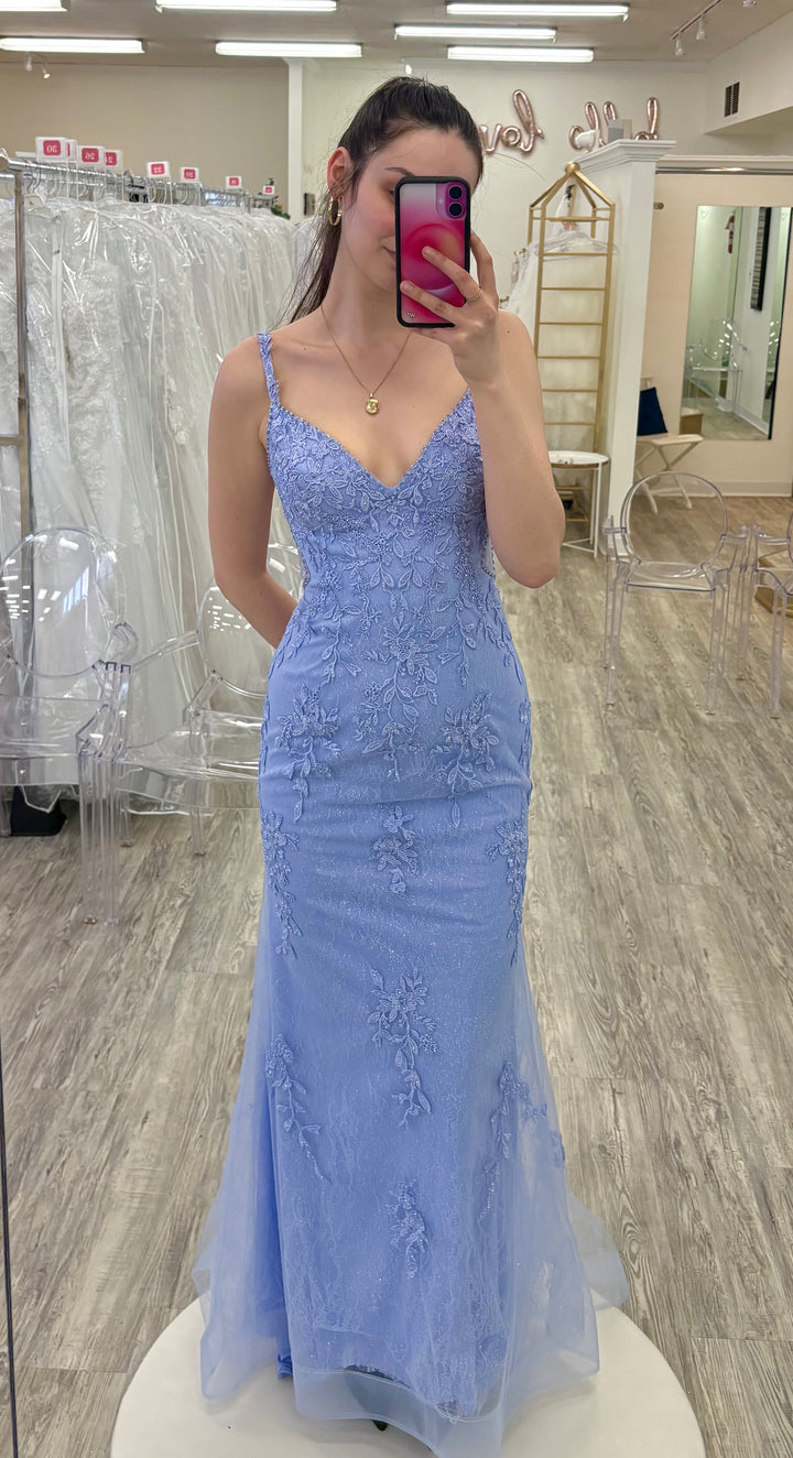 Woman wearing a peri lace dress in a fitting room.