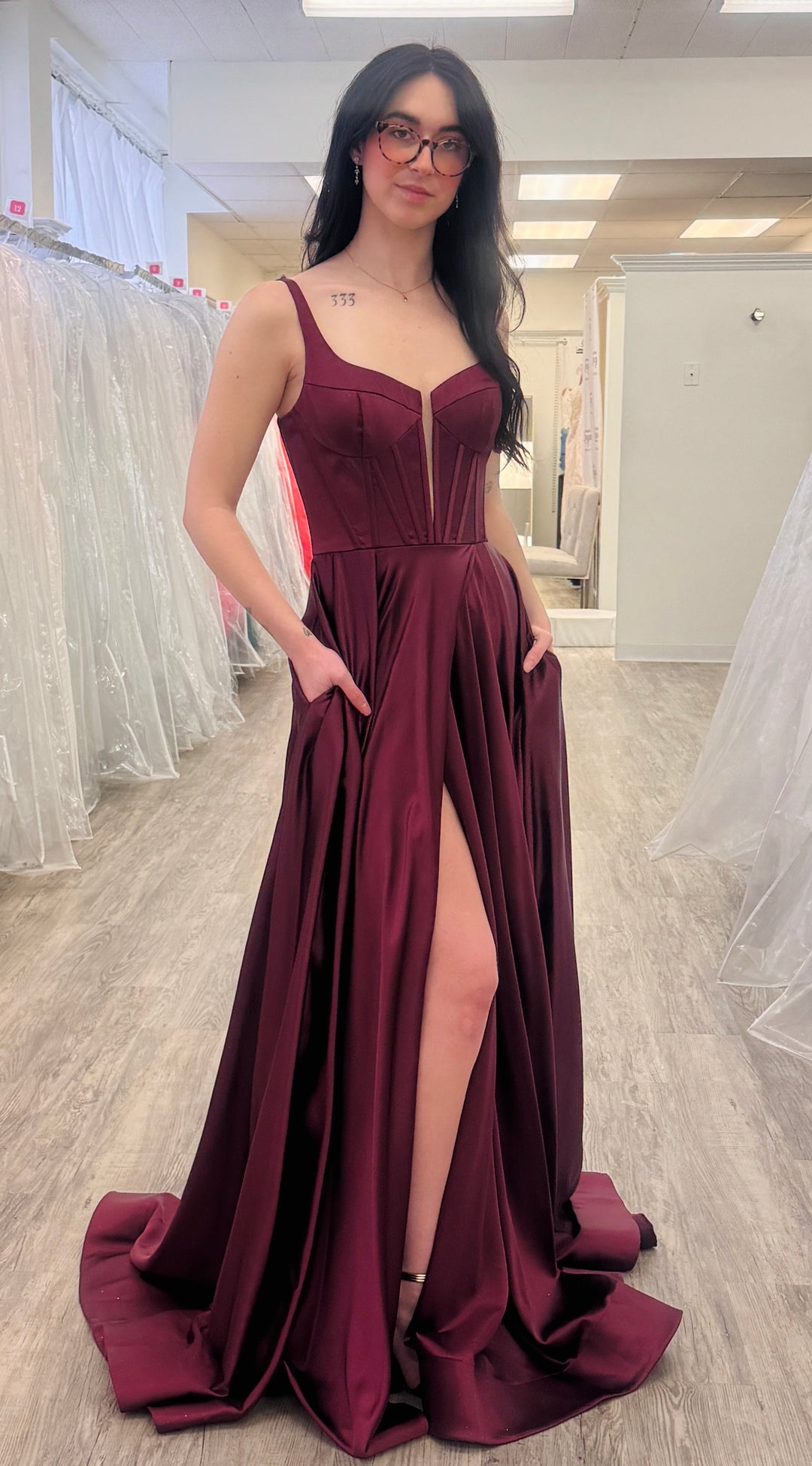 Woman wearing a wine color dress in fitting room.