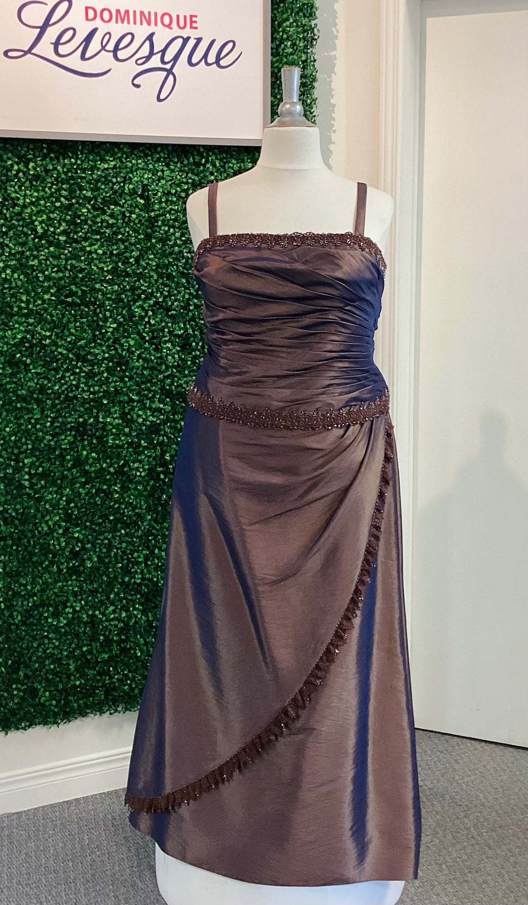 Cocoa dress on a mannequin with a green textured wall and white door in the background