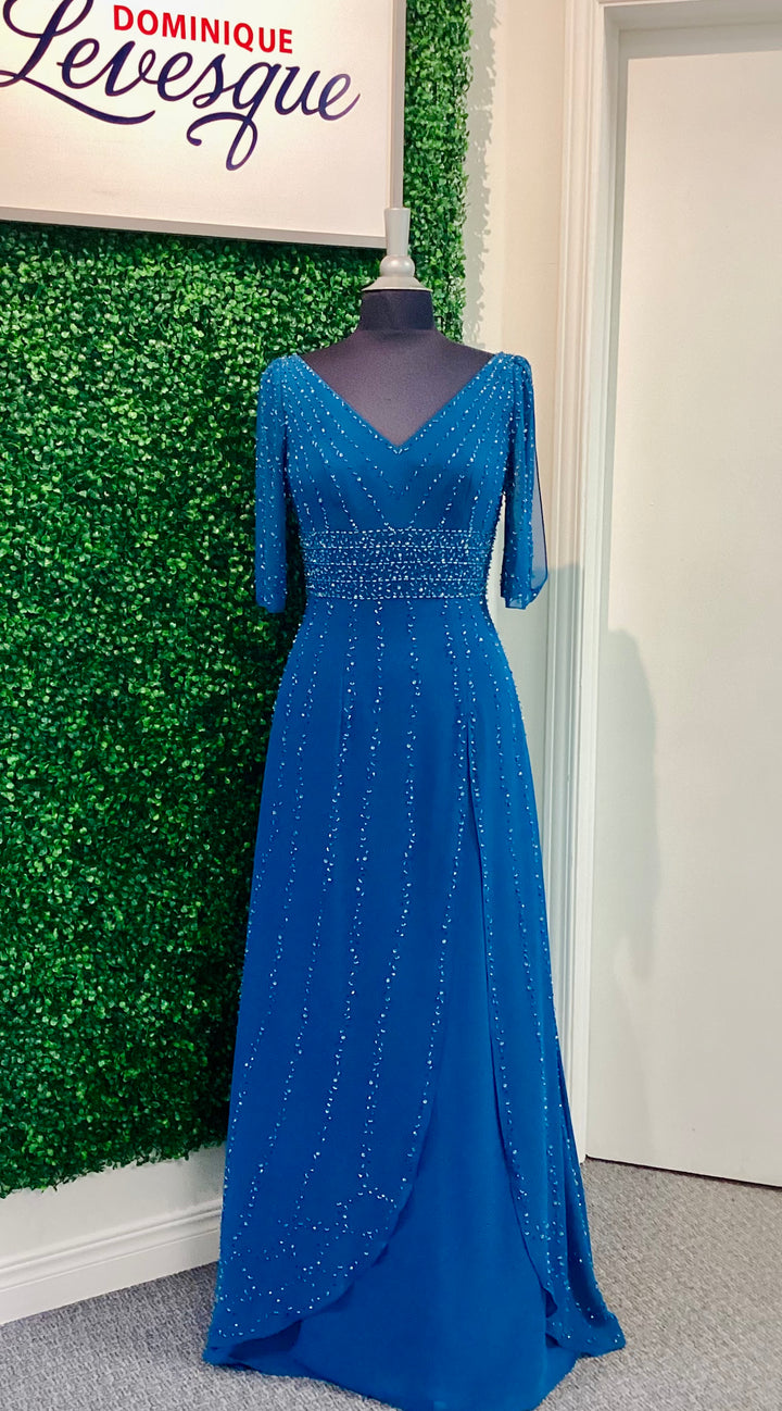 Blue evening gown on a mannequin against a green wall with &