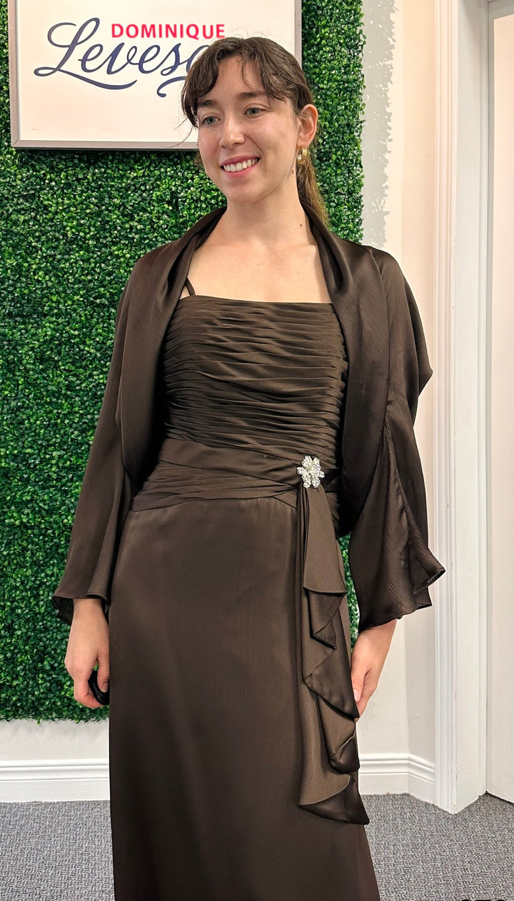 Woman wearing a brown dress with a matching jacket indoors.