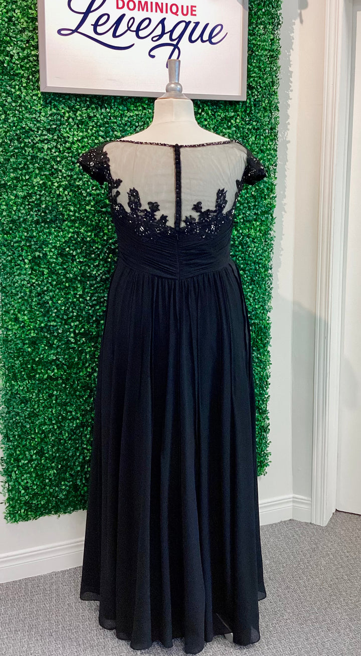 Black evening gown on a mannequin against a green leafy background with &