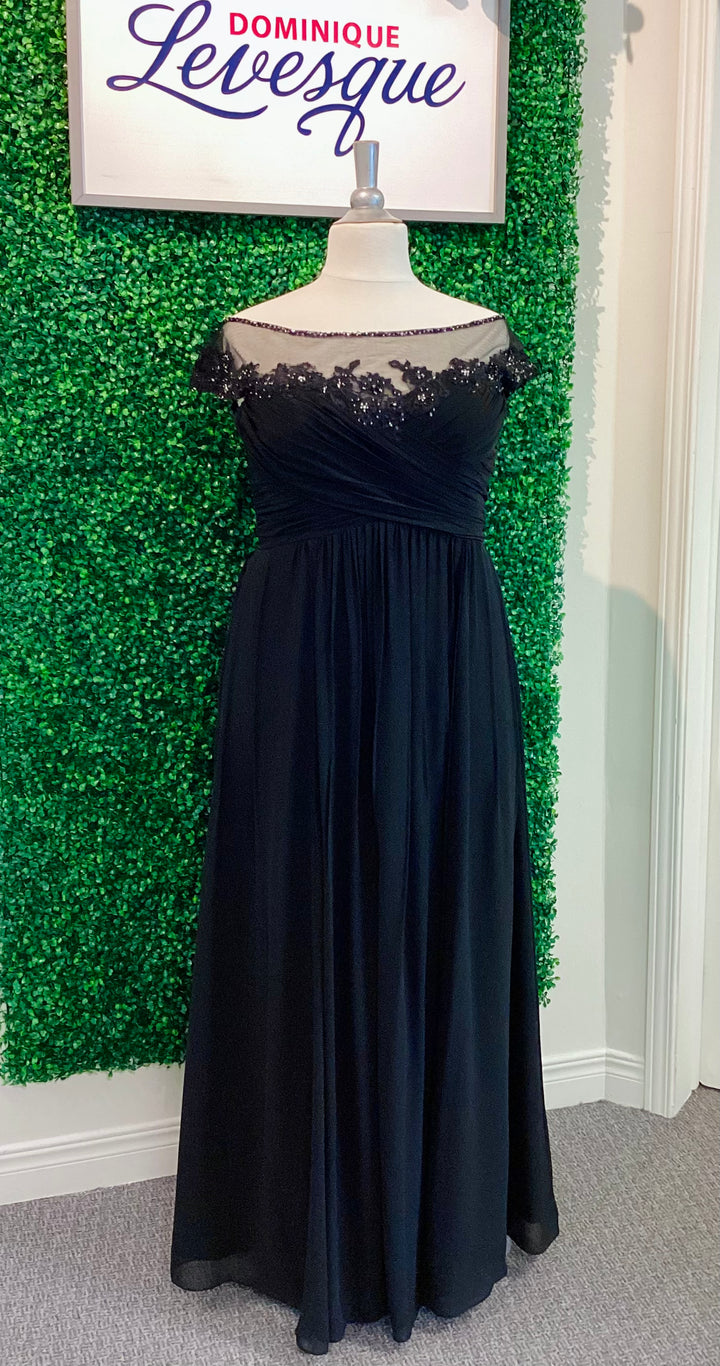 Black evening gown on a mannequin against a green leafy background with &