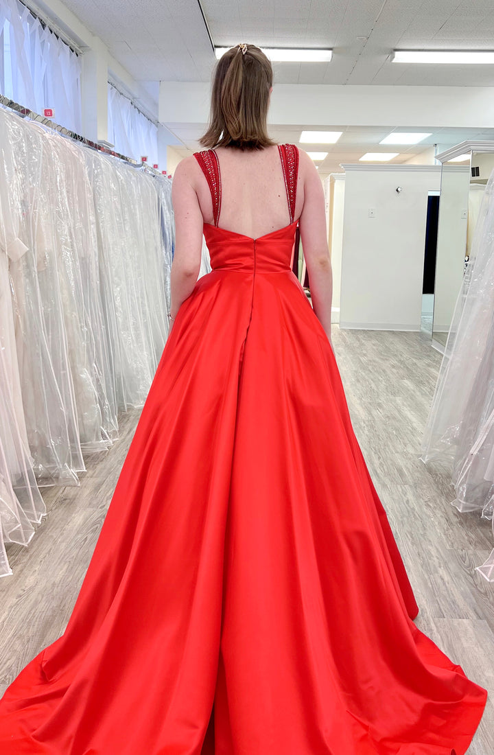 Red evening gown with open back in a fitting room setting