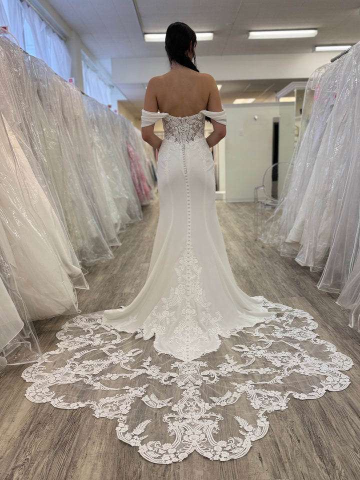 Woman wearing a white lace wedding dress in a store