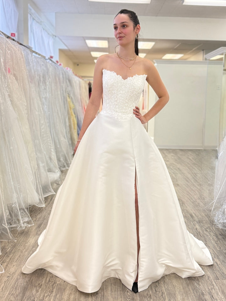 Woman wearing a white wedding dress in a store setting