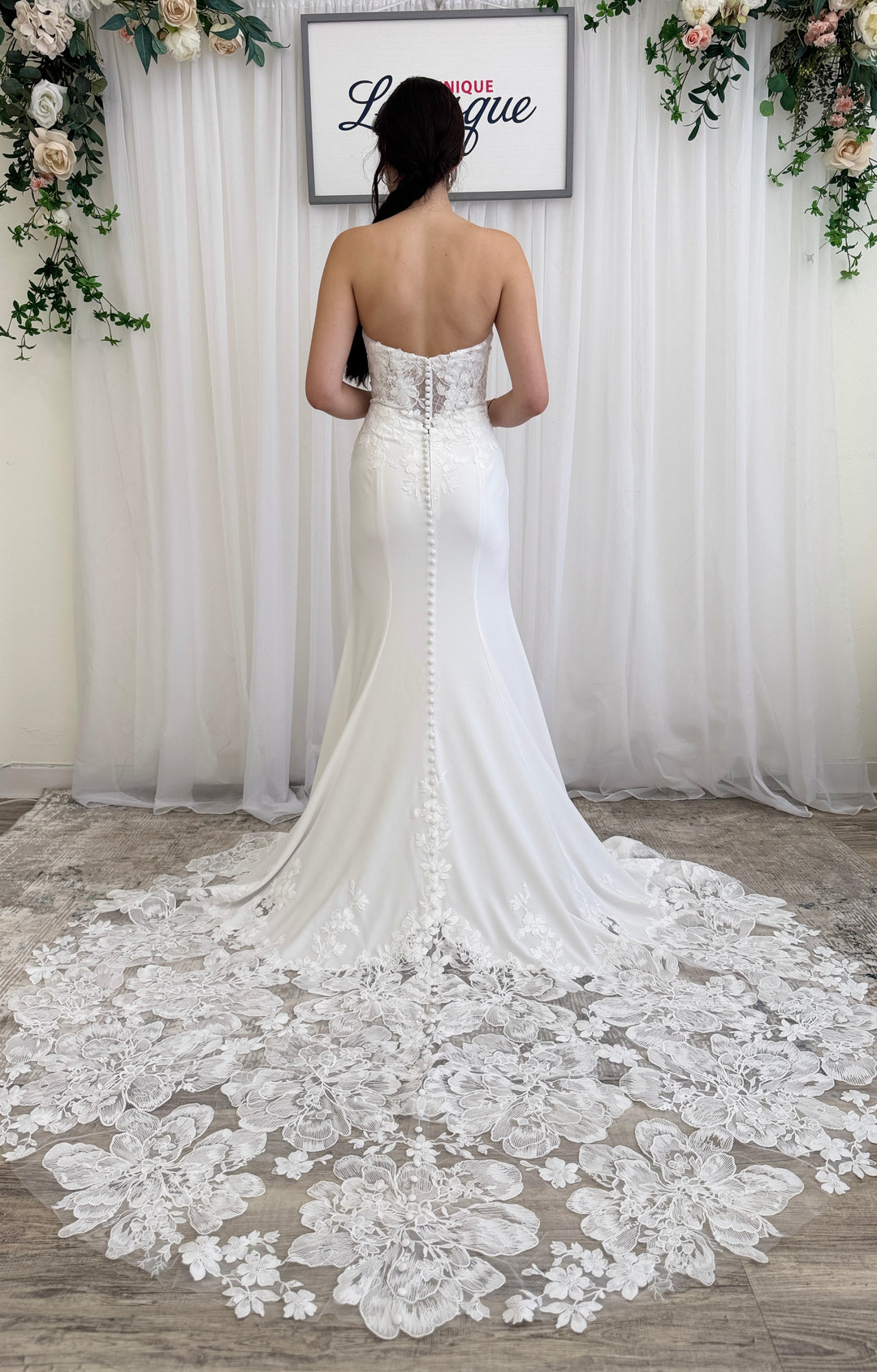 White wedding dress with intricate lace details on the train.