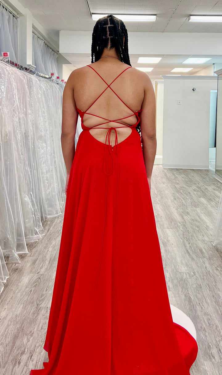 Women wearing a red dress with criss-cross back design in a fitting room.