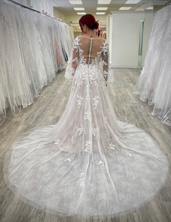 Blush wedding dress with long sleeves.