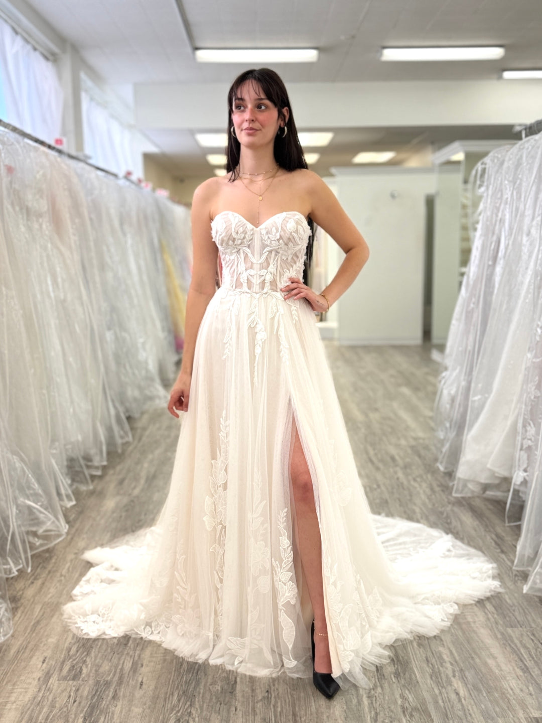 Woman wearing a white lace wedding dress in a store