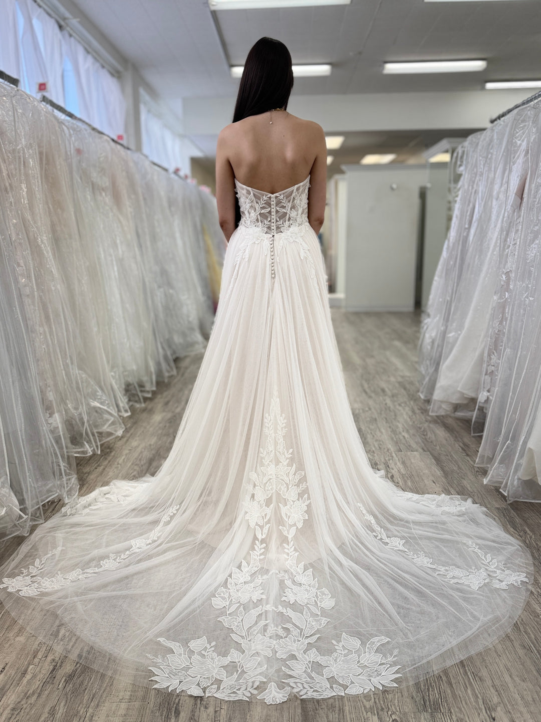 White wedding dress with lace details in a fitting room setting