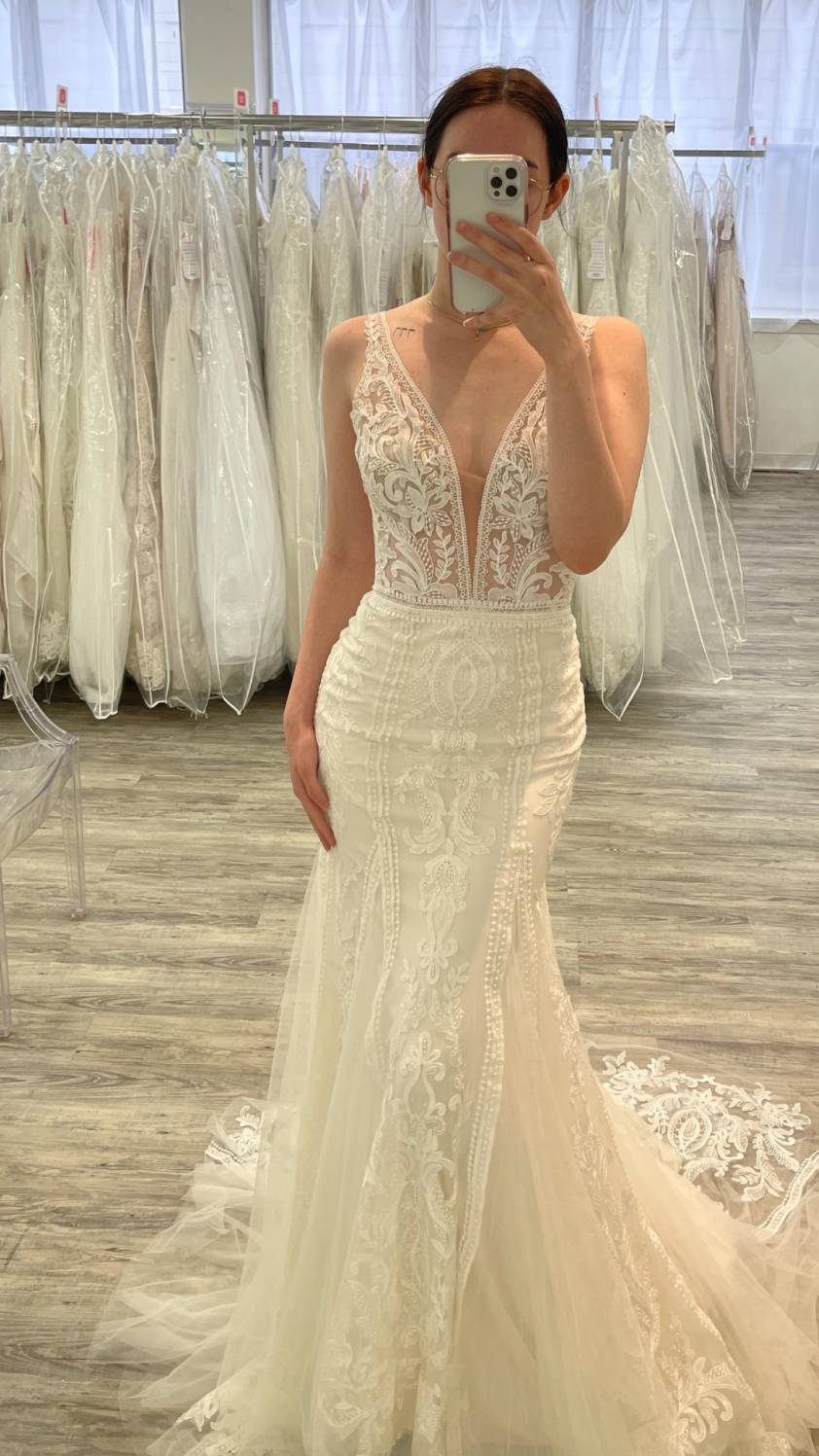 Bride in a lace wedding dress taking a selfie in the mirror
